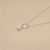 Collar de plata 925 con cadena fina, dije circular de nácar engastado con circones y una perla colgante.