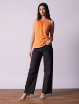 Musculosa negra de poliéster y elastano, con cuello redondo con frunces delanteros y abertura con botón en la espalda.