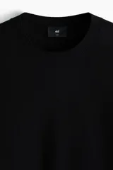 Remera de punto suave color negro, de corte slim fit, con cuello redondo acanalado y mangas cortas.