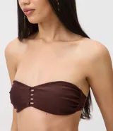 Top de bikini bandeau color marrón en tejido de microfibra texturizado, sin breteles y con detalle calado central de tiras horizontales.