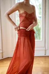 Pantalón semitransparente de pernera ancha, tiro medio y cintura elástica ajustable con lazadas, confeccionado en 100% viscosa.