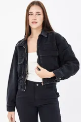 Chaqueta corta de denim negro con cuello clásico, cierre frontal con cremallera metálica, bolsillos de parche con solapa en el pecho y cintura elástica. Corte holgado.