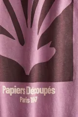 Remera de corte oversized en punto de algodón, con cuello redondo acanalado y mangas cortas de hombros caídos. Presenta un estampado frontal artístico con la inscripción Matisse y motivos abstractos.