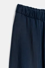 Pantalón de tiro medio con pierna ancha, confeccionado en mezcla de lyocell y viscosa. Cuenta con cintura elástica ajustable con cordones y bolsillos laterales ocultos en la costura.