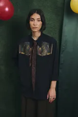 Camisa negra de manga larga con canesú frontal estampado con motivos artísticos de bodegón. Incluye una corbata fina integrada del mismo tono.