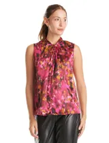 Blusa sin mangas de satén con estampado abstracto en tonos fucsia, rosa, naranja y negro. Presenta cuello alto con detalle de nudo frontal y cierre de botón en la espalda.