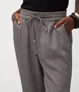Pantalón femenino de crepé con estampado geométrico en tonos grises y marrones, bajo afunilado, cintura elástica con lazo y bolsillos laterales.