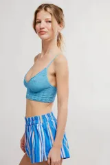 Bralette de encaje negro con copas triangulares, escote festoneado, tirantes finos regulables y banda inferior elastizada.