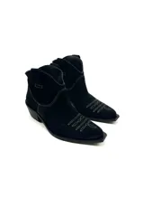 Botas de cuero vacuno color negro con caña baja bordada a tono, tacón bajo, punta alargada redondeada y suela cuadrada.