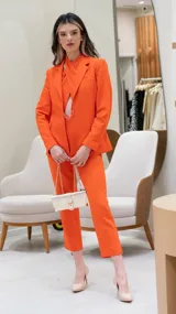 Mono largo negro con escote halter cruzado, abertura en el abdomen y cinturón dorado.