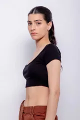 Top blanco de corte crop, escote redondo pronunciado y mangas cortas ajustadas.
