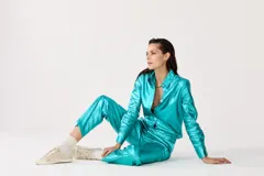 Pantalón de lino metalizado color turquesa, de corte clásico, tiro medio, piernas rectas y bolsillos laterales.