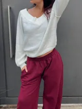 Sweater de punto color negro, con escote estilo bardot y mangas largas. Presenta un diseño acanalado y corte ajustado.