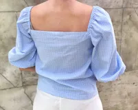 Blusa de mangas cortas abullonadas con estampado de cuadrillé azul y blanco, escote cuadrado y corte ajustado.