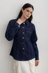 Chaqueta de denim color marrón, con corte entallado en la cintura, cierre frontal con botones metálicos y bolsillos superiores con solapa.