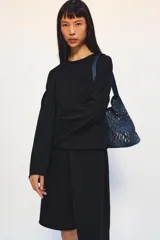 Bermuda de algodón color negro, con tiro medio, cintura elástica ajustable con cordones y bolsillos laterales ocultos en costura.