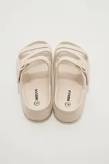 Sandalias de goma color negro con diseño de tres tiras cruzadas y hebilla lateral ajustable.