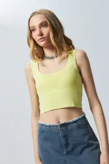 Top negro sin mangas con escote cuadrado, confeccionado en tejido con leve brillo y costuras asimétricas en el frente.