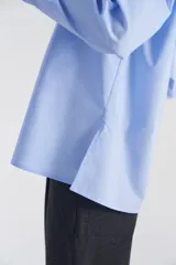 Camisa celeste de poplín de algodón, de corte amplio, con cuello camisero y botones. Estampado trasero con la frase “Bananas are Blue”.