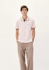 Chomba de manga corta color negro con cuello y tapeta interior en color gris claro. Presenta un pequeño bordado en el pecho y detalles de ribete en gris en el cuello y las mangas.