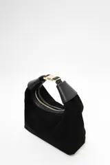 Cartera tipo hobo de Lolita, confeccionada en gamuza color bordó, con diseño de asa integrada y cierre superior. Presenta detalles en cuero liso en los extremos del asa y logo de la marca grabado en el frente.