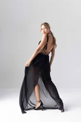 Vestido largo negro de gasa transparente con bordados dorados en el corpiño y tirantes finos.