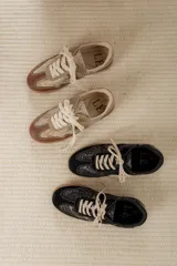 Championes urbanos de diseño acolchado, combinando tonos marrones, beige y detalles metalizados con textura. Cuentan con cordones al tono y suela de goma color caramelo.
