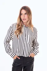 Camisa de manga larga con diseño de rayas verticales en color blanco y negro, cuenta con cuello clásico, cierre frontal de botones y un bolsillo en el pecho.