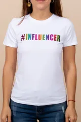 Remera blanca de algodón con cuello redondo y mangas cortas. Estampado frontal con la palabra '#INFLUENCER' en letras de colores.