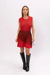 Vestido corto tejido de punto color rojo con hilos dorados, sin mangas y con falda acampanada. Incluye cinturón marrón con flecos.