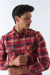 Sobrecamisa de algodón a cuadros color ladrillo, con interior de corderito, cierre con botones, bolsillos tipo cartera y logo en goma. El modelo usa talle M.