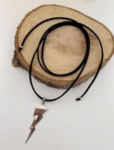 Collar tipo choker con tira de gamuza negra y dije colgante en forma de rayo realizado en alpaca.