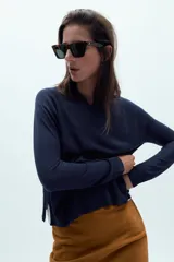 Jersey de punto liso, color azul brillante, con cuello redondo y manga larga. Presenta acabados en rib en puños, cuello y bajo, con aberturas laterales en el ruedo.