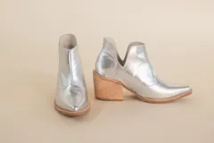 Botas plateadas de cuero con puntera en punta y taco de madera.