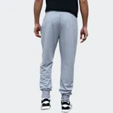 Pantalón de jogging gris con cintura elástica ajustable mediante cordón, puños en los tobillos y logo de la marca bordado en la pierna izquierda.