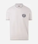 Remera de manga corta Marfinno de corte regular, color blanco, con cuello redondo y detalles en contraste azul marino. Presenta un escudo bordado en el pecho y confección en mezcla de algodón y poliéster.