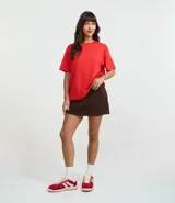 Remera de corte boxy con cuello redondo y mangas cortas. Confeccionada en algodón, presenta un diseño minimalista sin estampas con sisa caída.