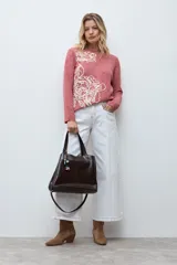 Sweater de punto color rojo melange, con cuello redondo, manga larga y detalle de bordado floral en relieve en color crudo en el frente.