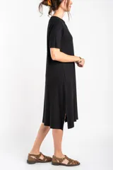 Vestido midi negro de manga corta, confeccionado en tejido de punto acanalado, con cuello redondo y corte recto.