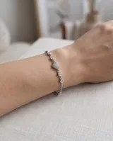 Pulsera de plata 925 compuesta por una cadena delicada intercalada con circonias blancas en chatón y un dije central en forma de corazón completamente pavimentado de circonias.