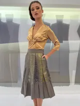 Falda midi de lana estampada a mano con engomado brillante tono sobre tono y tablas irregulares hechas a mano. Tiene bolsillos laterales.