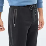 Pantalón de jogging de corte recto, confeccionado en tejido de punto piqué color negro. Presenta cintura elástica con cordón ajustable, bolsillos laterales y puños elásticos en los tobillos.