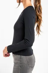 Remera negra de manga larga, con cuello redondo y tejido acanalado, de corte ajustado al cuerpo.