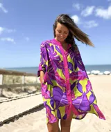 Camisero de playa con estampado de hojas tropicales en tonos fucsia, violeta y verde lima. Presenta un diseño holgado, cuello mao y cierre frontal con botones a tono.