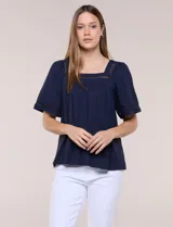 Blusa de corte holgado color marfil, confeccionada en mezcla de modal y algodón, con escote cuadrado y mangas cortas adornadas con detalles de puntilla calada.