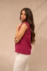 Blusa fucsia sin mangas con cuello redondo y detalles de encaje broderie en los hombros.