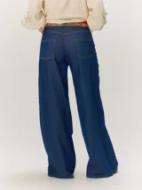 Pantalon de jean azul de corte ancho y relajado, con tiro alto y costuras decorativas verticales.