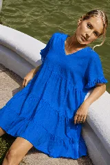 Vestido corto azul eléctrico de lino, con escote en V, mangas cortas con volados y diseño en capas escalonadas.