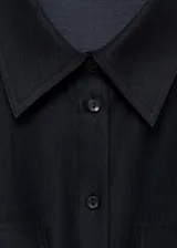 Camisa de corte recto y diseño clásico con cuello camisero, cierre frontal de botones y dos bolsillos con solapa en el pecho. Presenta mangas largas con puños abotonados y está confeccionada en una mezcla de lyocell y poliéster.