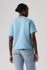 Remera celeste de manga corta, con cuello redondo y diseño holgado con aberturas laterales en el dobladillo.